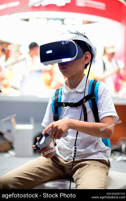 little chinese boy plays game with VR in ST exhibition