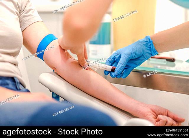 Close-up Of Doctor Taking Blood Sample From Patient's Arm in Hospital for Medical Testing