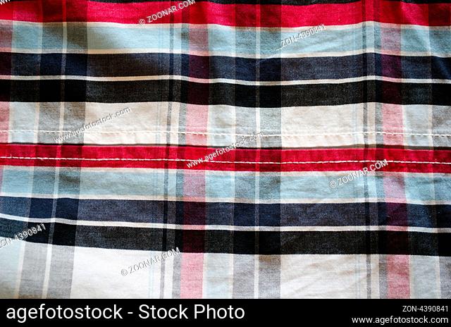 closeup of shirt cotton fabric material and square shape red blue black ornaments background