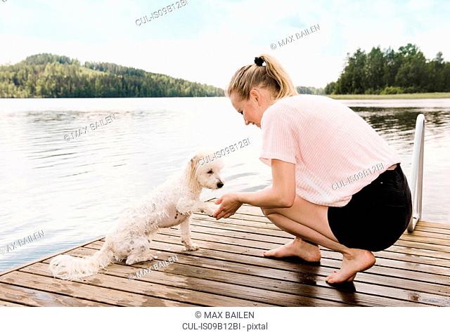 Woman holding coton de tulear dog's paw after swimming, Orivesi, Finland