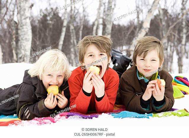 3 kids eating fruit