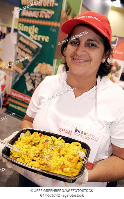 Americas Food and Beverage Show, Hispanic woman, cook, seafood paella, rice. Convention Center. Miami Beach. Florida. USA