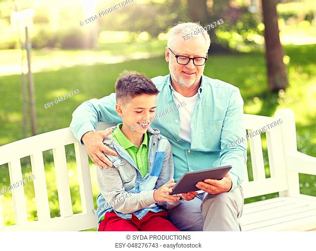 grandfather and boy with tablet pc at summer park