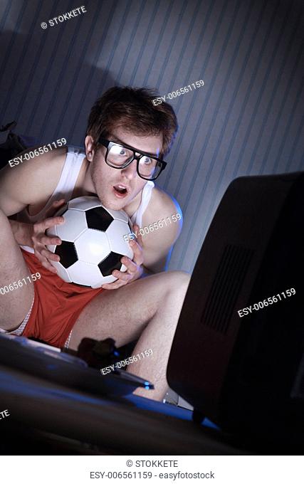 Young man soccer fanatic getting really into the soccer game on television