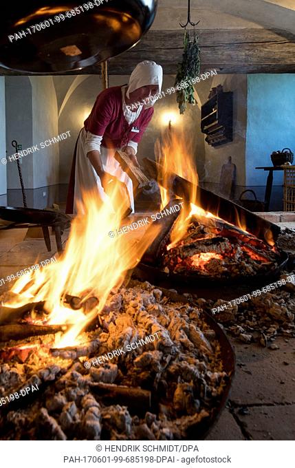 Annett Boehmer makes a fire at the open hearth kitchen of the Herrenhaus (manor house) of the Mildenstein castle in Leisnig, Germany, 31 May 2017