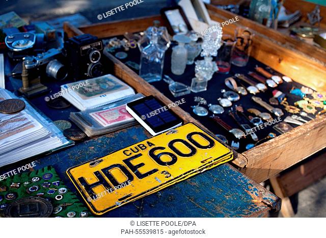 An old licence plate, historic cameras and used wrist watches are on display at a flea market on the Plaza de Armas in Havana,  Cuba, 28 January 2015