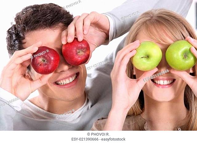 Man and woman covering her eyes with apples