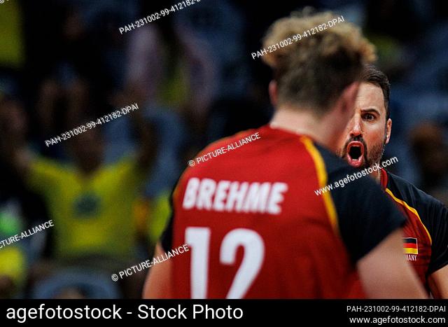 01 October 2023, Brazil, Rio de Janeiro: Volleyball, Men: Olympic Qualification, Group A, Cuba - Germany. Germany Georg Grozer (r) and Anton Brehme react during...