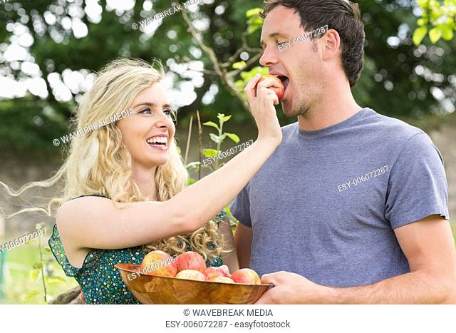 Blonde woman feeding her boyfriend with an apple
