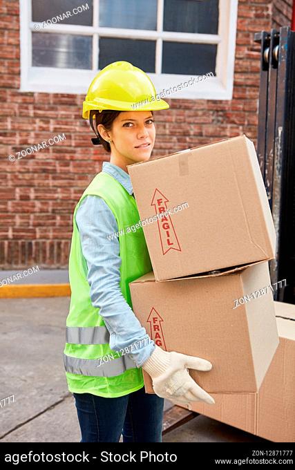 Frau als Lagerarbeiter im Versandhandel transportiert Pakete für die Lieferung