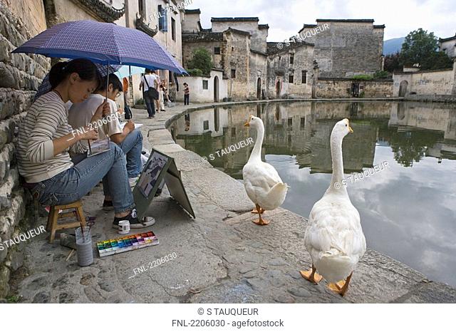 Artists painting at pondside, Hongcun, Yi County, Anhui Province, China
