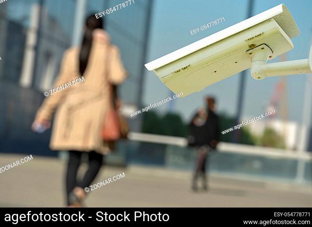 security CCTV camera or surveillance system with woman on blurry background