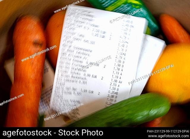 PRODUCTION - 27 November 2023, Bremen: ILLUSTRATION - A receipt lies on top of the groceries in a shopping bag. Photo: Sina Schuldt/dpa
