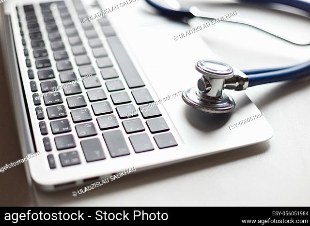 Virtual doctor. Computer and stethoscope. Soft focus