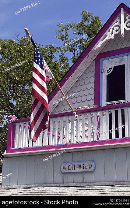 An American flag hangs from a Carpenter Gothic (Gingerbread) cottage the Campgrounds Oak Bluffs Martha's Vineyard Massachusetts USA