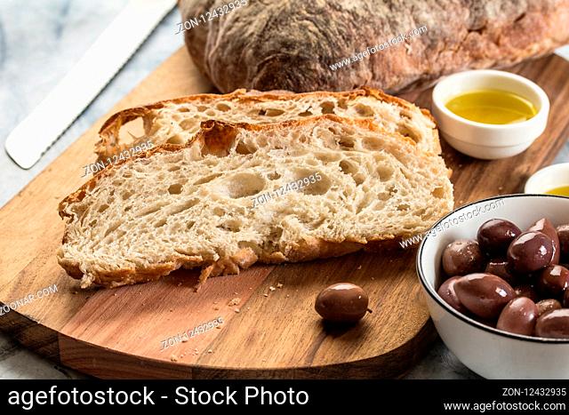 Sliced bread on wooden board - selective focus on Italian Ciabatta