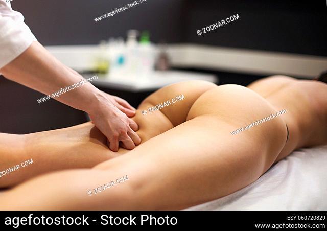 Deep tissue massage on a hip of the woman gluteus muscles