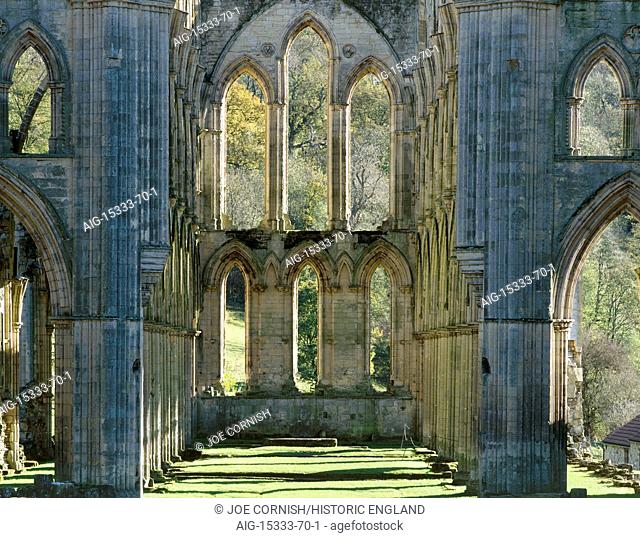 RIEVAULX ABBEY, North Yorkshire. The window at the east end of the abbey church showing autumn colour on the trees beyond. Gothic architecture