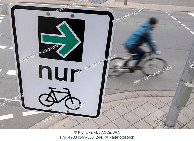 13 March 2019, Hessen, Darmstadt: A sign with a ""green arrow"" only for cyclists allows cyclists to turn right at red traffic lights