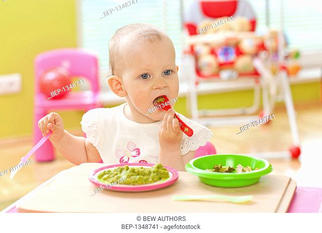 Adorable baby girl eating some vegetables