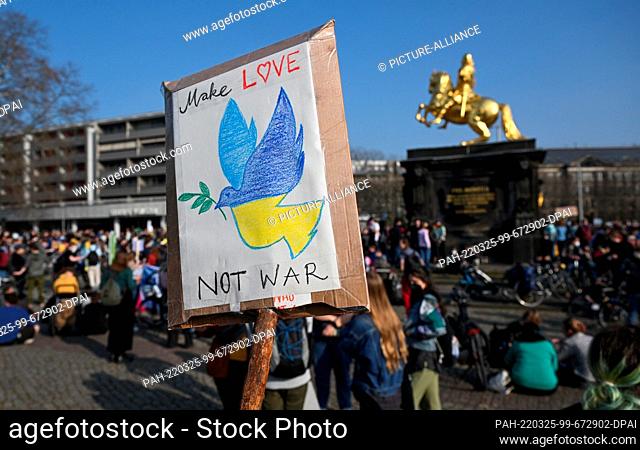 25 March 2022, Saxony, Dresden: ""Make Love Not War"" and a peace dove in the colors of Ukraine can be seen on the sign of a participant at a Fridays for Future...