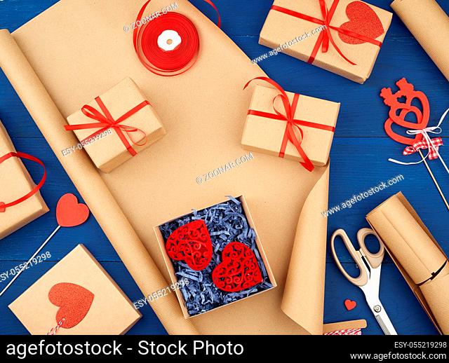 brown kraft paper, packed gift bags and tied with a red ribbon, red heart, set of items for making gifts with your own hands. Gift wrapping