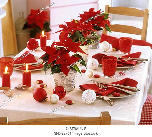 Christmas table decorated with poinsettias and baubles