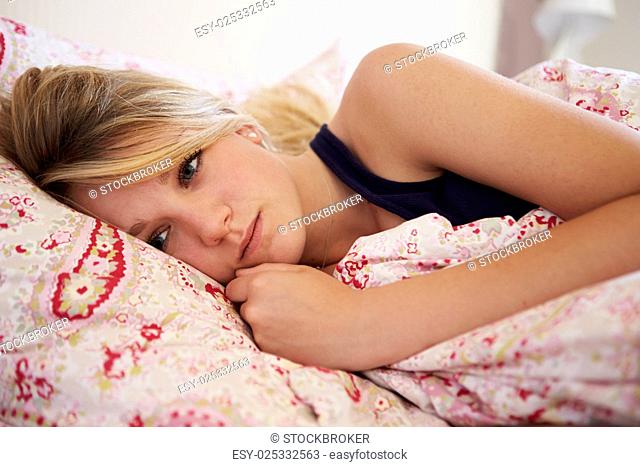 Worried Teenage Girl Lying In Bed