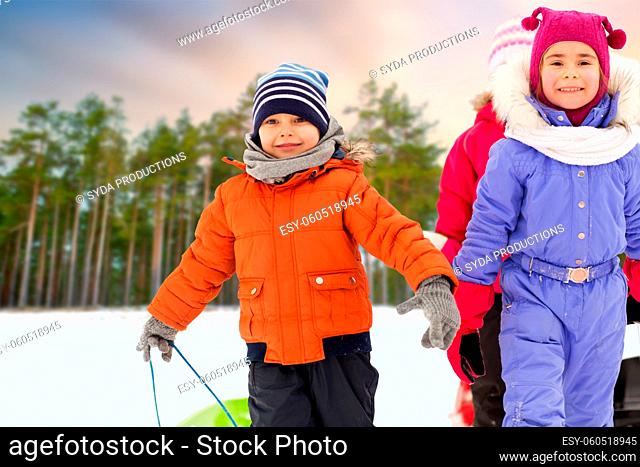 happy little children with sleds in winter