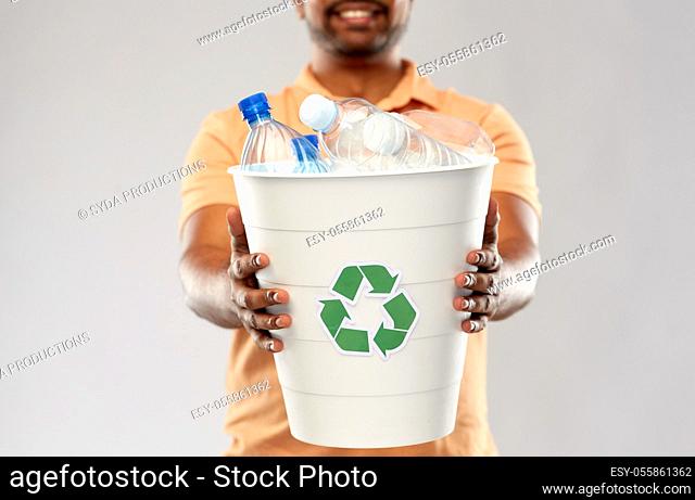 close up of young indian man sorting plastic waste