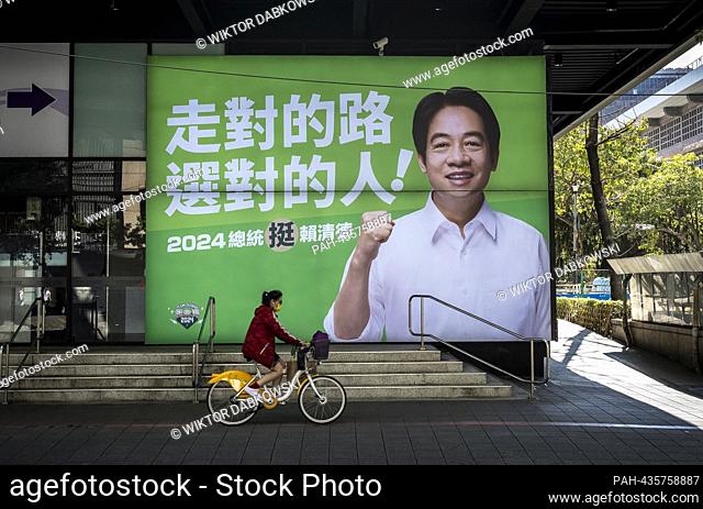 Cyclist pass Democratic Progressive Party (DPP) candidate William Lai election banner in Taipei, Taiwan on 22/11/2023 The opposition to the ruling DPP party is...