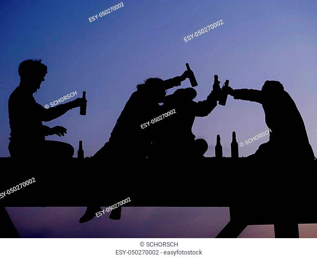 Silhouette of four friend drinking beer