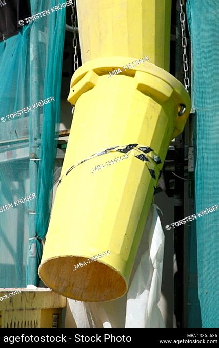Construction site, yellow downpipe for building rubble on the facade of a scaffolded house, Bremen, Germany, Europe