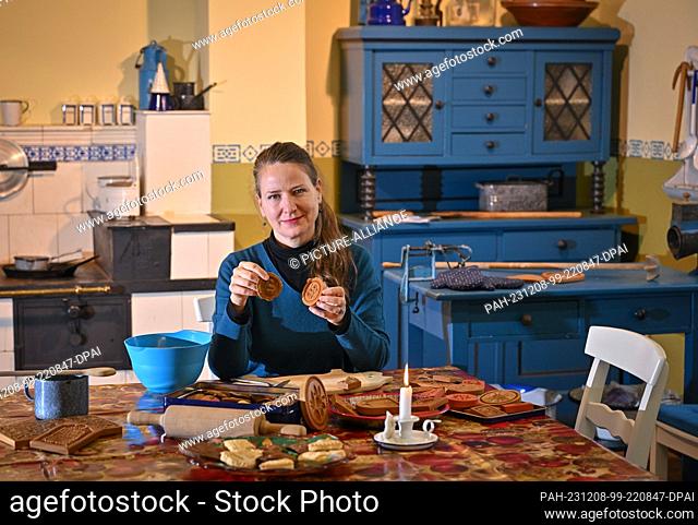 07 December 2023, Brandenburg, Frankfurt (Oder): Halina Muchow, museum educator, sits in ""Uroma's kitchen"" from the 1920s in the Viadrina Museum and makes...