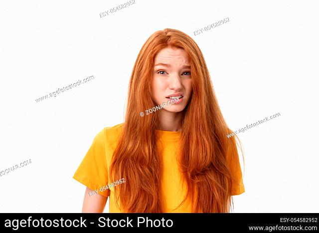 Happy cheerful young woman wearing her red hair looking at camera. Ginger student girl relaxing indoors after college