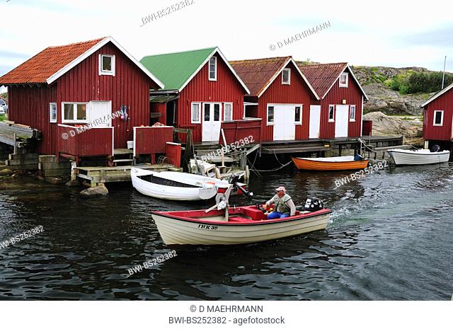 fishing boat in front of fishing huts, Sweden, Bohuslaen, Smoegen