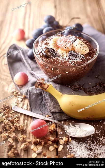 Chocolate chia pudding with fruit in the glass bowl on the wooden table