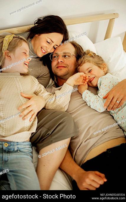 Family lying in bed