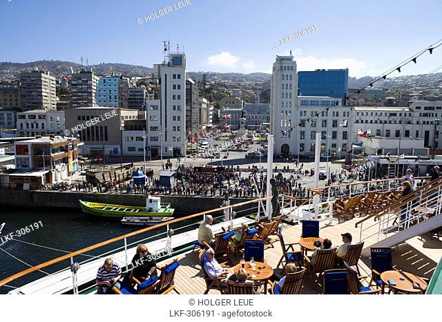 People on deck of cruiseship MS Deutschland Deilmann Cruises and view at city as vessel departs, Valparaiso, Chile, South America, America