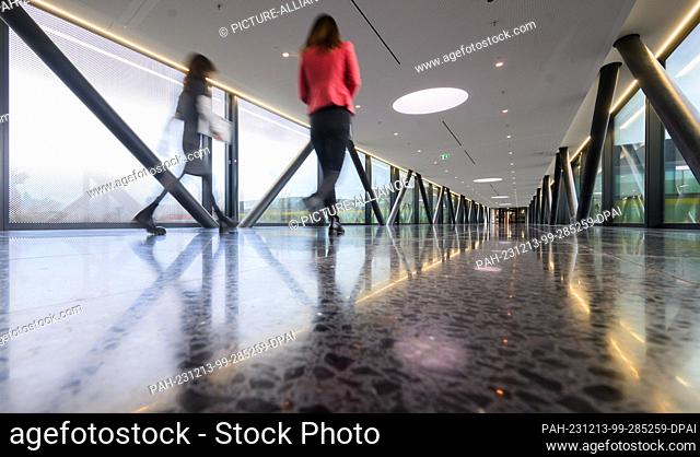 13 December 2023, Lower Saxony, Hanover: Employees walk across the bridge between the north and south buildings at Continental's new corporate headquarters