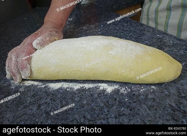 Swabian cuisine, preparing Bruckhölzer, Schlanganger, Sperrknechte from potato dough, making potato dough, kneading potato dough, flour, men's hand, vegetarian