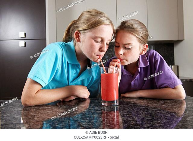 Girls drinking fruit juice with straws