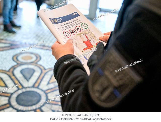 30 December 2019, Berlin: Police officers distribute notices for the ban on fireworks on New Year's Eve in a cafe in Berlin Schöneberg near Pallasstraße