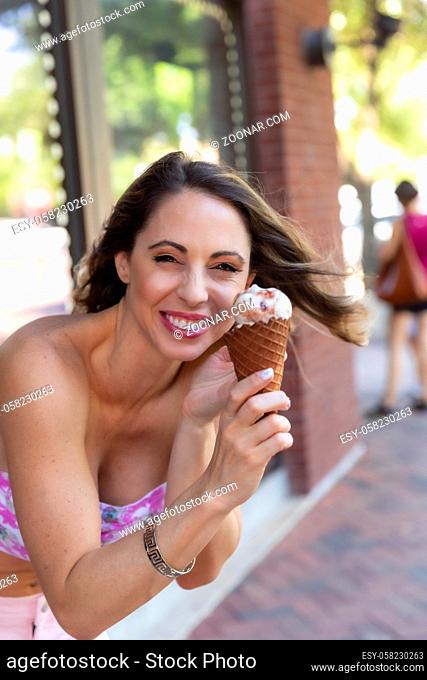 A beautiful Brunette model enjoys some ice cream on a hot summers day