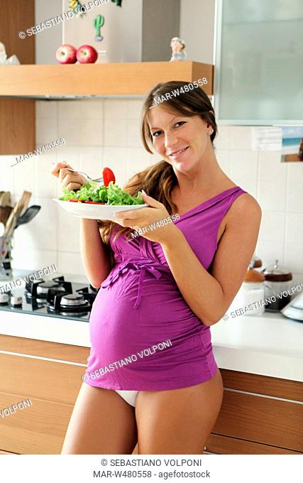 donna incinta con un'insalata