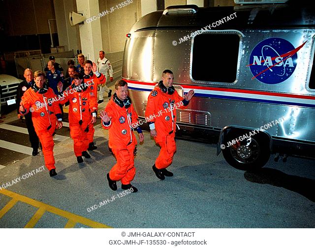 The STS-104 crew heads for the Astrovan that will take them to Launch Pad 39B. Leading are Commander Steven W. Lindsey (left) and Pilot Charles O