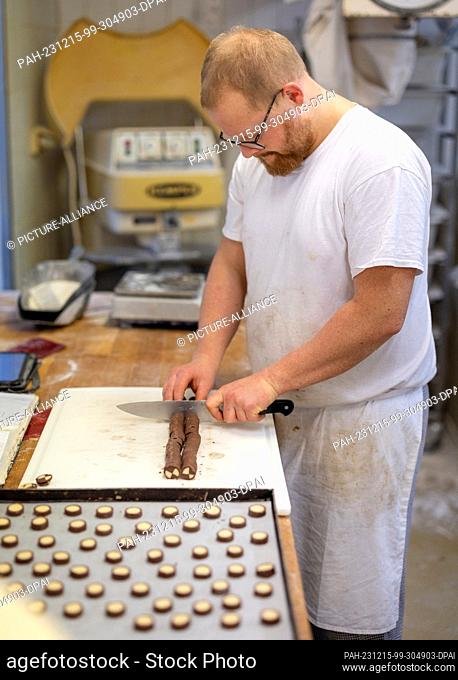 PRODUCTION - 13 December 2023, Thuringia, Erfurt: Baker Philipp Florschütz prepares cookies in the Lobenstein bakery and confectionery