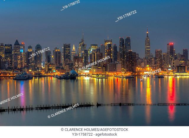 The Manhattan skyline in New York City reflects off the surface of the Hudson River during morning twilight as viewed looking east from New Jersey, USA