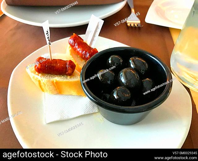 Spanish tapas: black olives and txistorra. Spain