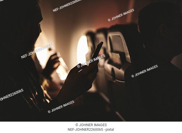 Person holding cell phone in plane